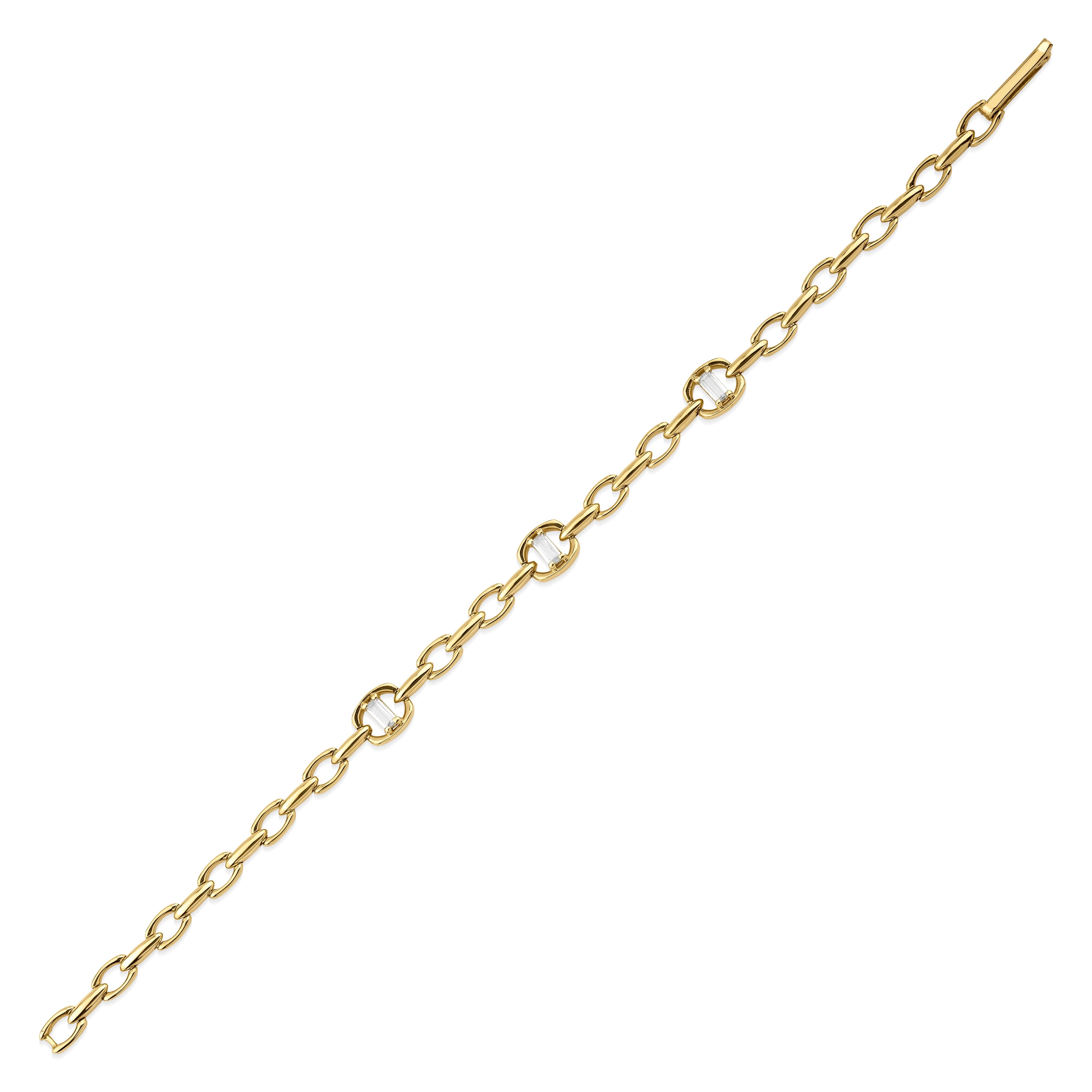 yellow gold open-link bracelet with baguette-cut stones on white background