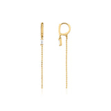 yellow gold huggie hoop earrings with baguette stone and beaded chain drop on white background