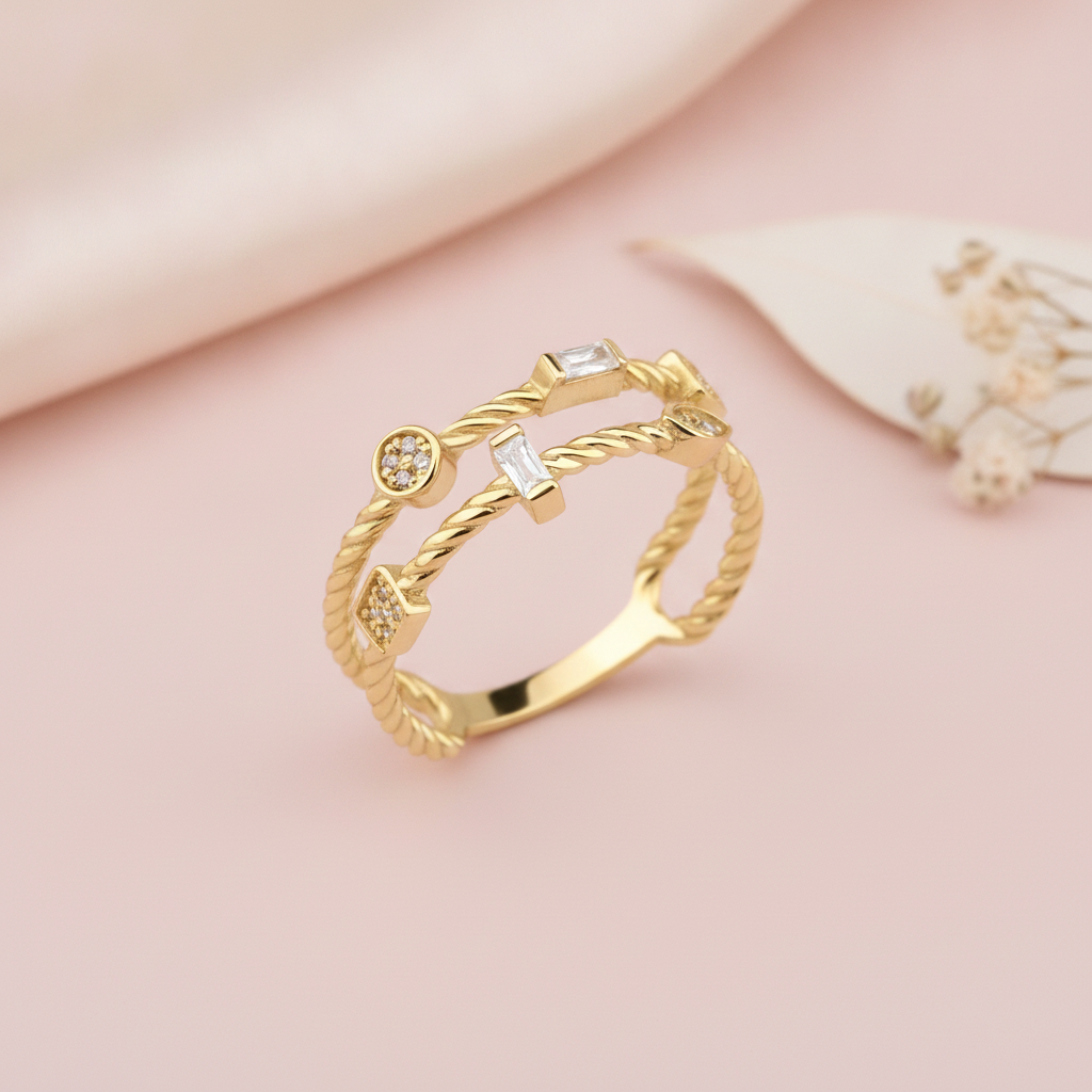 gold twisted double-strand ring with baguette and pave stones, on pink satin with dried flowers and a leaf