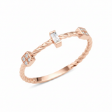 rose gold twisted ring with baguette and square cluster stones on white background