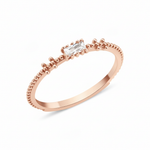 rose gold beaded band ring with baguette stone on white background