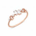 rose gold beaded ring with baguette and round stones on white background