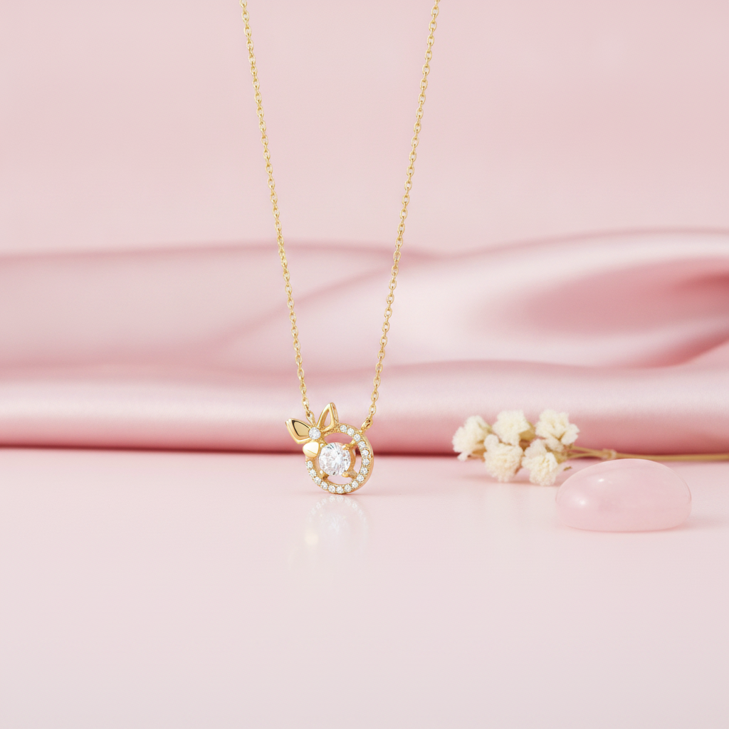 gold bow and halo pendant necklace with clear center stone on pink satin with dried flowers