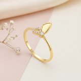 gold butterfly loop ring with clear pave stones on pink and cream fabric with baby's breath flowers
