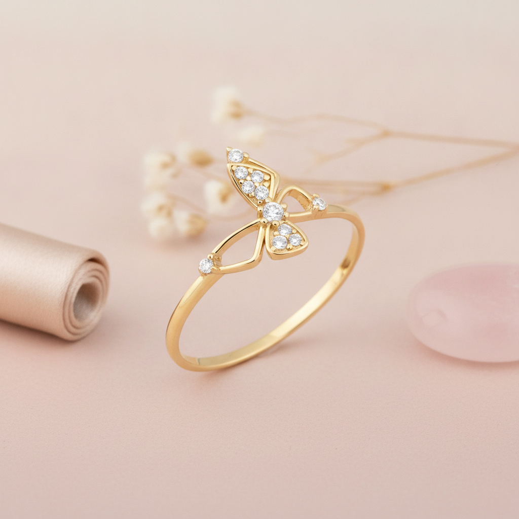 gold butterfly ring with pave-set stone wings displayed on blush pink background with baby's breath flowers and a rose quartz stone
