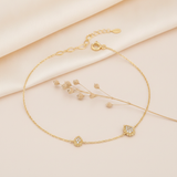 gold chain bracelet with two pave teardrop stations edged in beaded gold, laid in a circle on cream satin with dried flowers