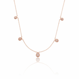 rose gold teardrop station necklace on white background