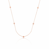rose gold faceted nugget station necklace with small stone accents on a white background