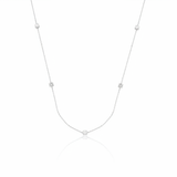 white gold faceted nugget station necklace with small stone accents on a white background