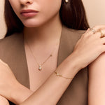 model wearing the gold clover charm necklace