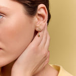 model wearing the gold petal drop earrings
