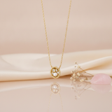 yellow gold beaded circle pendant necklace with a pearl and clear stones, styled on cream silk with dried baby's breath and a rose quartz stone