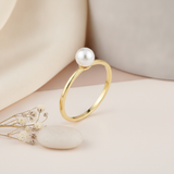 yellow gold slim band ring with a single pearl, styled on cream silk with dried baby's breath