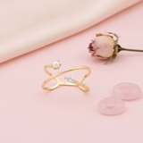 yellow gold split band ring with White CZ stones and a pearl, styled on cream silk with dried baby's breath