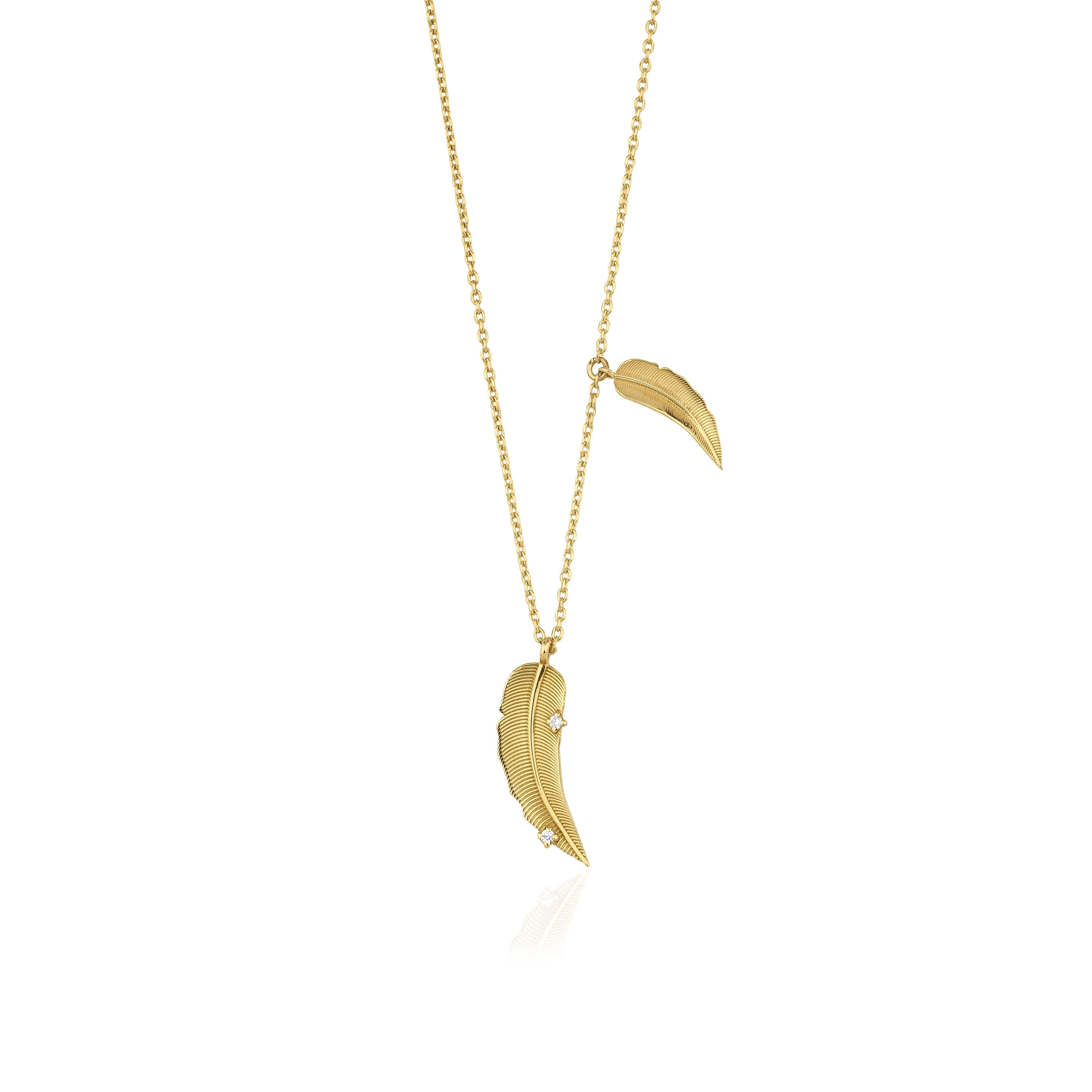 yellow gold double feather pendant necklace on white background