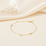 yellow gold chain bracelet with square stone stations, styled on cream silk with dried baby's breath