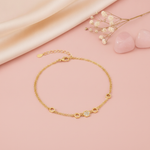 yellow gold double-strand hexagon bracelet with a honeycomb motif, styled on a pink background with dried baby's breath and rose quartz stones