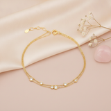 double strand gold bracelet with scattered round bezel-set stones, shown on pink fabric with baby's breath and a rose quartz stone