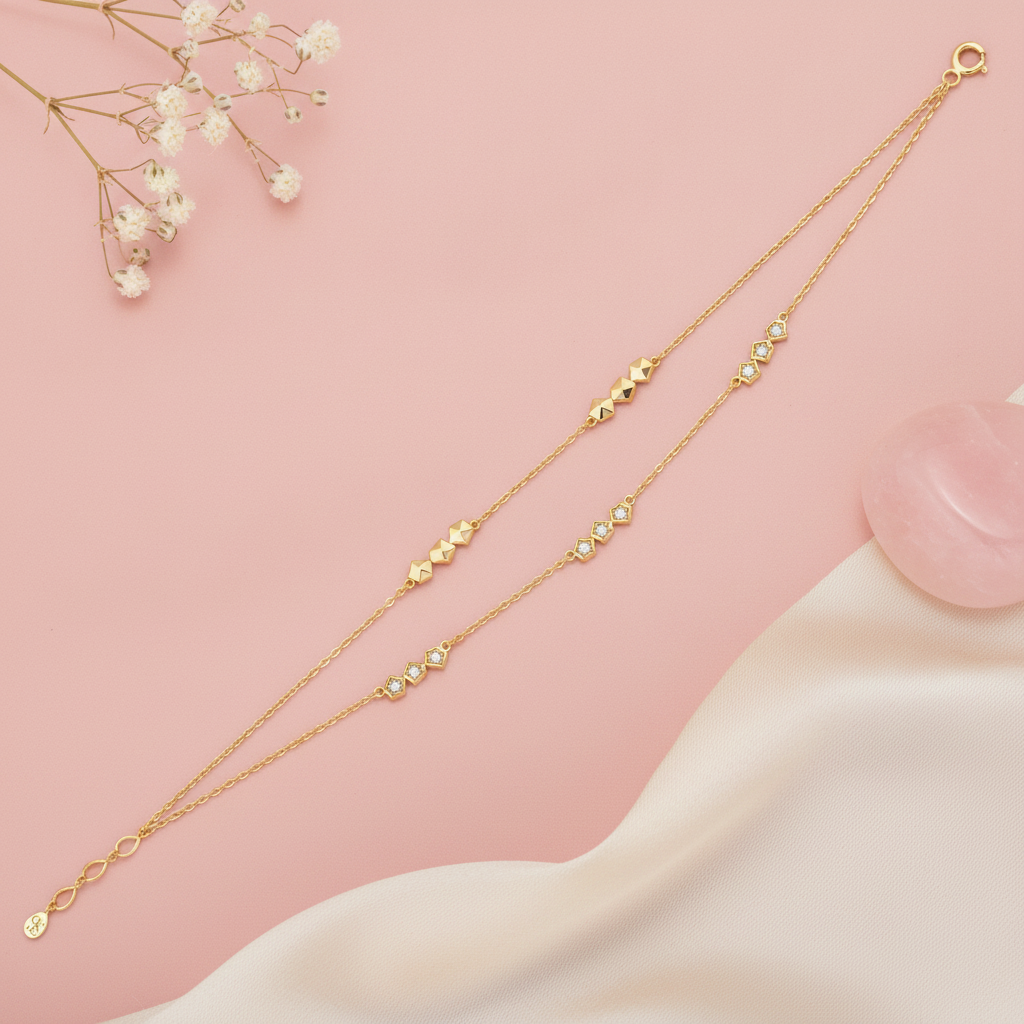 double strand gold bracelet with pyramid stud clusters and small stone accents, shown on pink fabric with baby's breath and a rose quartz stone