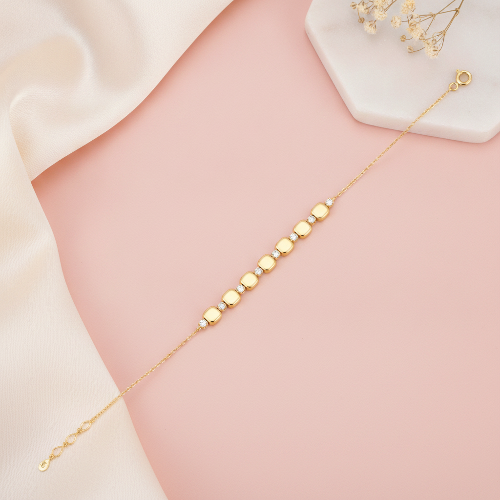 double strand beaded gold bracelet with kite-shaped stone stations, shown on pink fabric with a rose quartz stone and baby's breath
