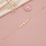 gold chain bracelet with graduated cushion-shaped stone stations, shown on pink fabric with a dried rose and a rose quartz stone