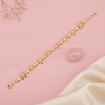 gold bracelet with alternating polished beads, textured stations, and small arrow charms, shown on pink fabric with baby's breath
