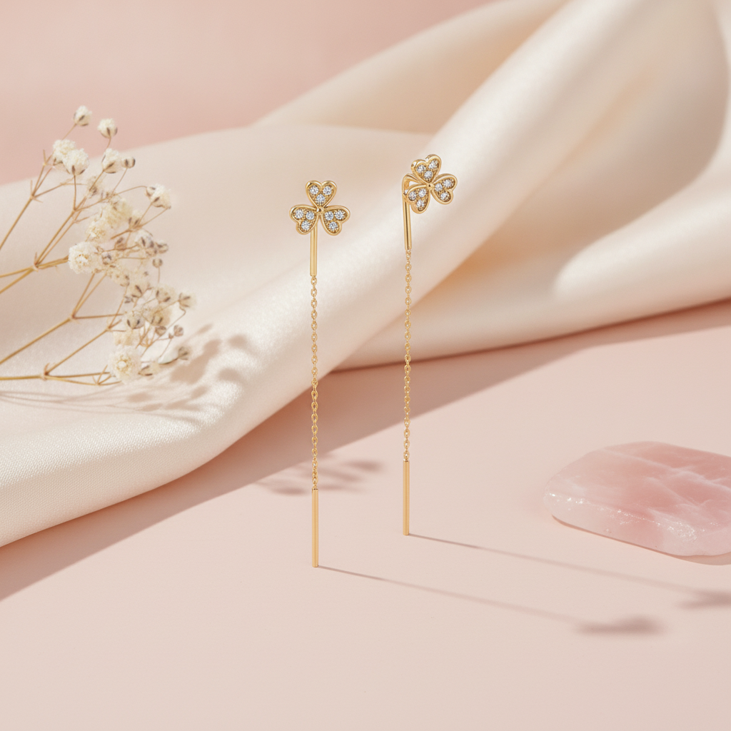 gold clover threader earrings with pave White CZ stones on a blush background with dried baby's breath and a rose quartz stone