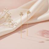 gold clover threader earrings with pave White CZ stones on a blush background with dried baby's breath and a rose quartz stone