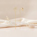 gold open circle threader earrings with a White CZ stone cluster and bar drop on a warm beige background with dried baby's breath