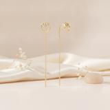 gold open circle threader earrings with a White CZ stone cluster and bar drop on a warm beige background with dried baby's breath