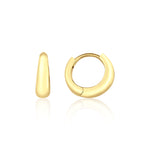 yellow gold volume huggie earrings on white background