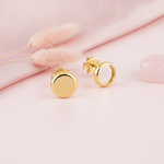 gold circular disc stud earrings with butterfly backs on a pink background with dried pink bunny tail grass