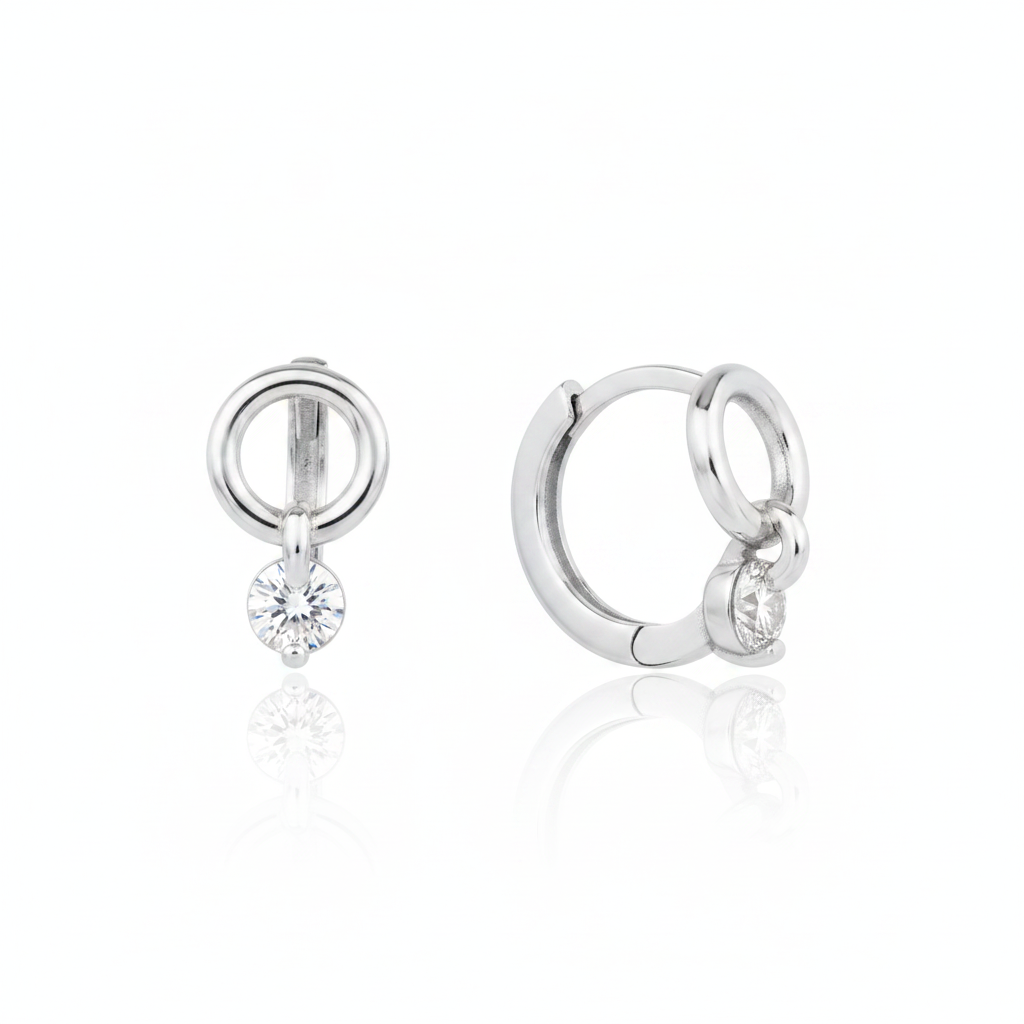 white gold circle drop huggie earrings on white background