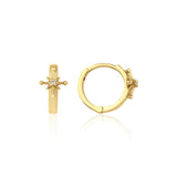 yellow gold starburst huggie earrings on white background