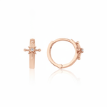 rose gold starburst huggie earrings on white background