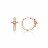rose gold starburst huggie earrings on white background