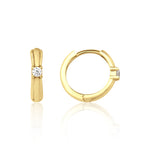 yellow gold solitaire huggie earrings on white background