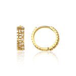 yellow gold notched huggie earrings on white background