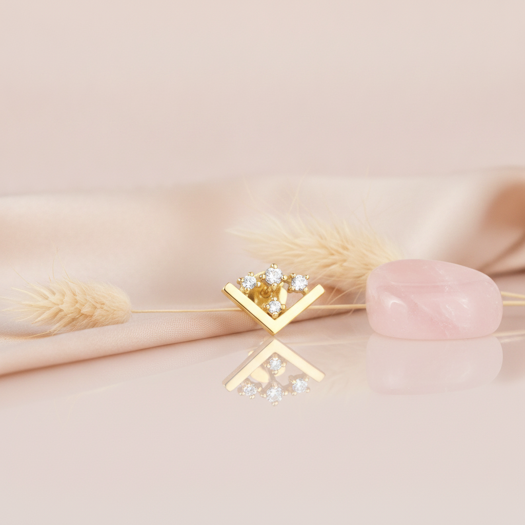 gold chevron stud earring with four round White CZ stones on a pink background with dried wheat and a rose quartz stone