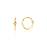 yellow gold quatrefoil huggie earrings on white background