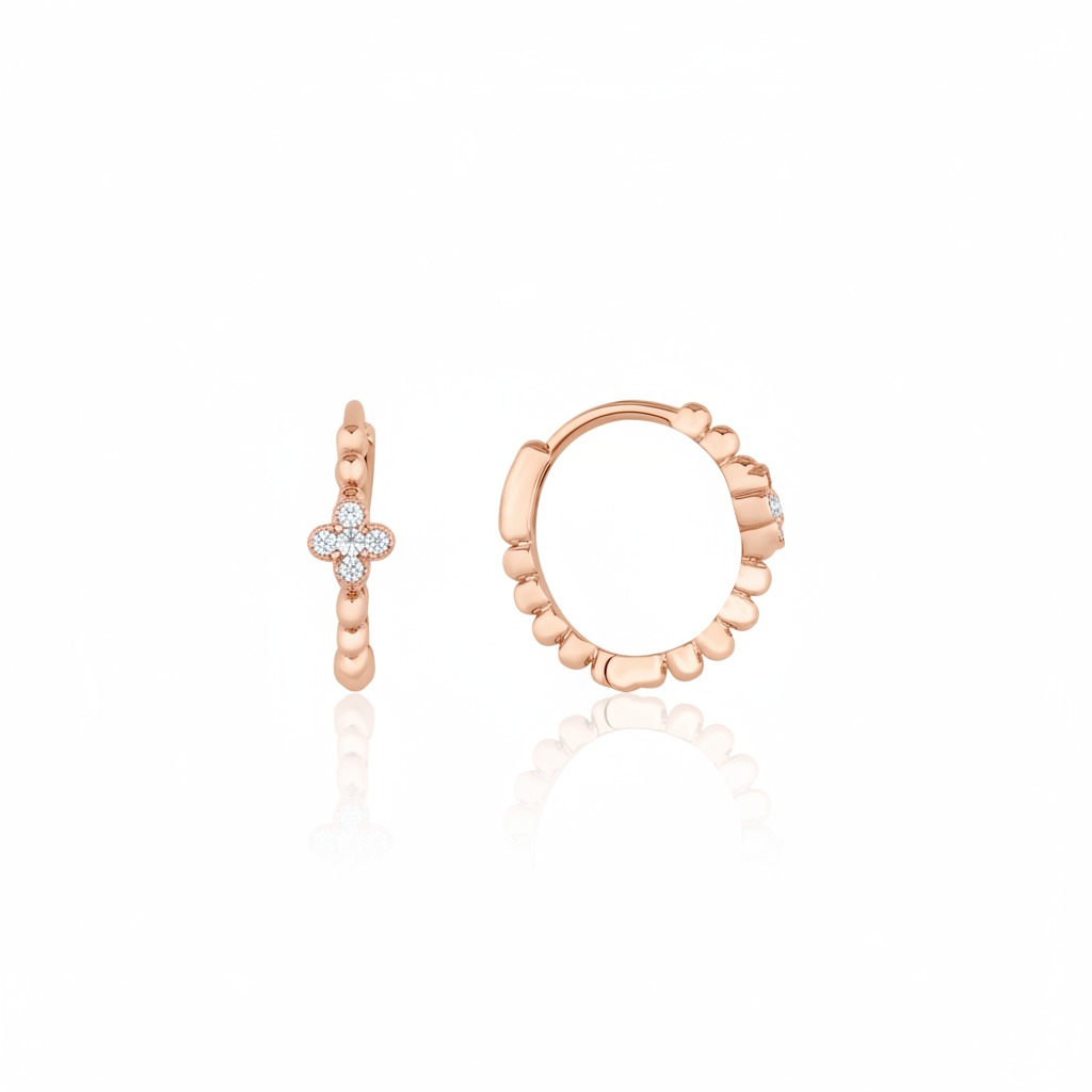 rose gold quatrefoil huggie earrings on white background