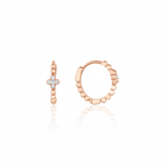 rose gold quatrefoil huggie earrings on white background