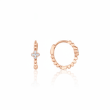 rose gold quatrefoil huggie earrings on white background