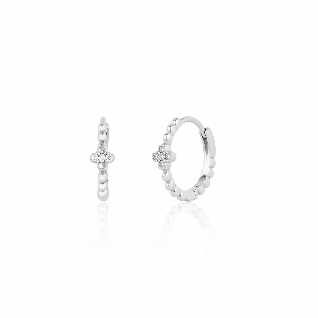 white gold quatrefoil huggie earrings on white background