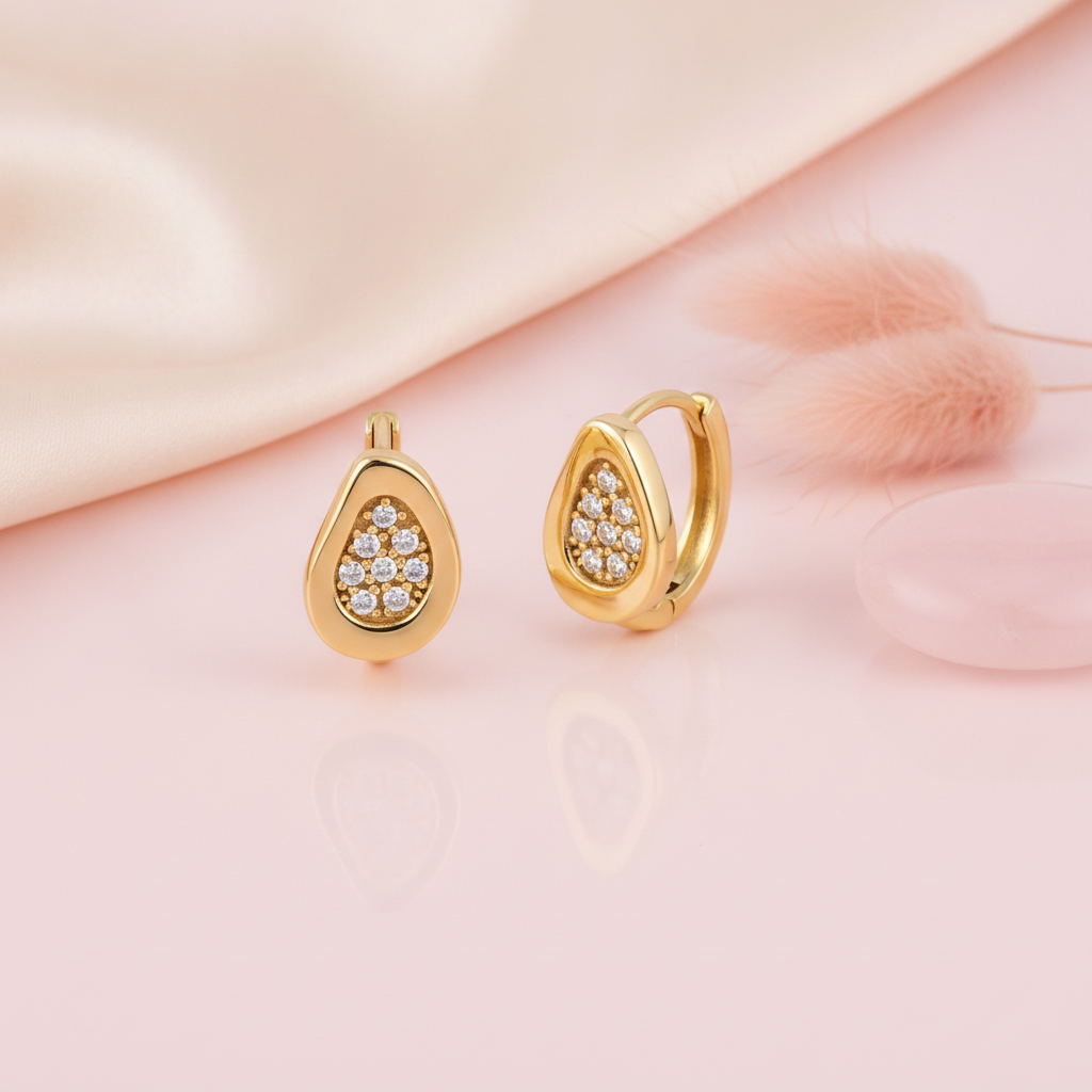 gold teardrop huggie hoop earrings with pave White CZ stones on a blush background with dried bunny tail grass and a rose quartz stone