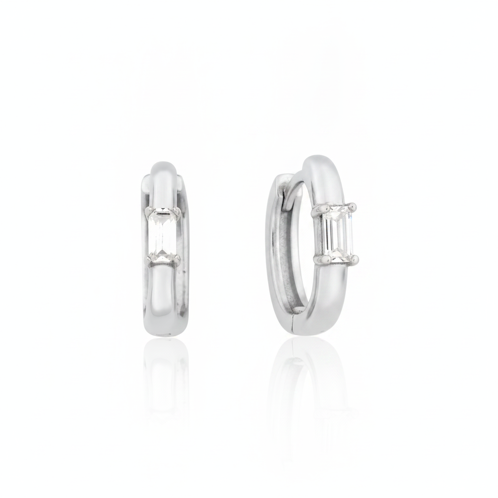 white gold baguette huggie earrings on white background