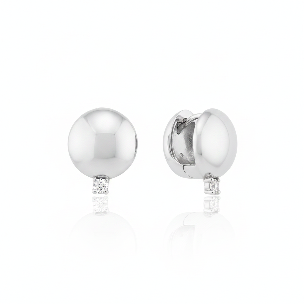 white gold polished dome huggie hoop earrings with a single clear stone on white background