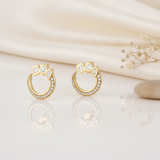 open gold hoop stud earrings topped with square, round, and marquise clear stones, styled on an ivory background with draped silk and dried flowers