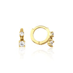 yellow gold huggie hoop earrings with two cascading clear stones on white background