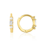 yellow gold huggie hoop earrings with a baguette-cut and round clear stones on white background
